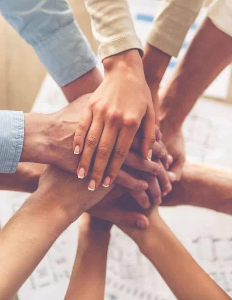 Hands resting together in a stack.
