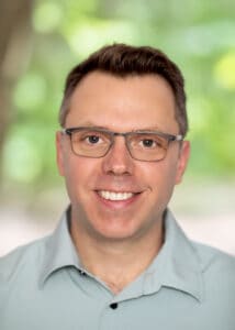 Warm smiling man with glasses, professional headshot for counselling, mental health support, and psychotherapy services at Wellspring Counselling, emphasizing compassionate mental health care in Ontario.