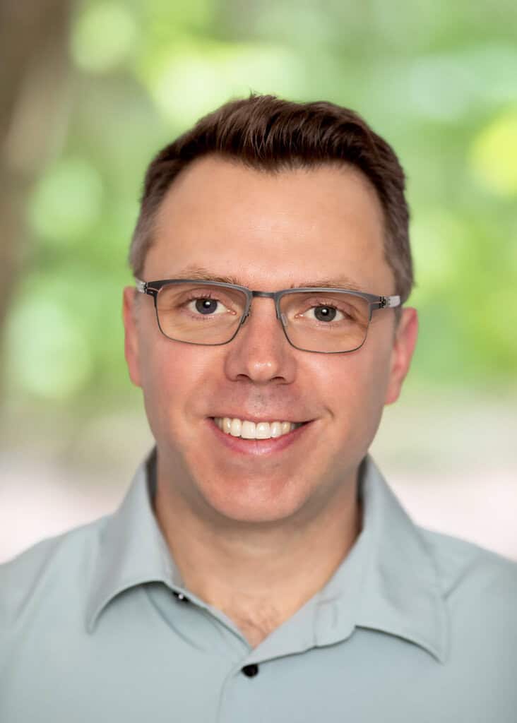 Warm smiling man with glasses, professional headshot for counselling, mental health support, and psychotherapy services at Wellspring Counselling, emphasizing compassionate mental health care in Ontario.